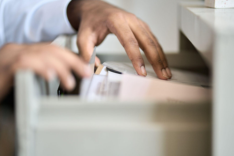 male hands searching through filed documents